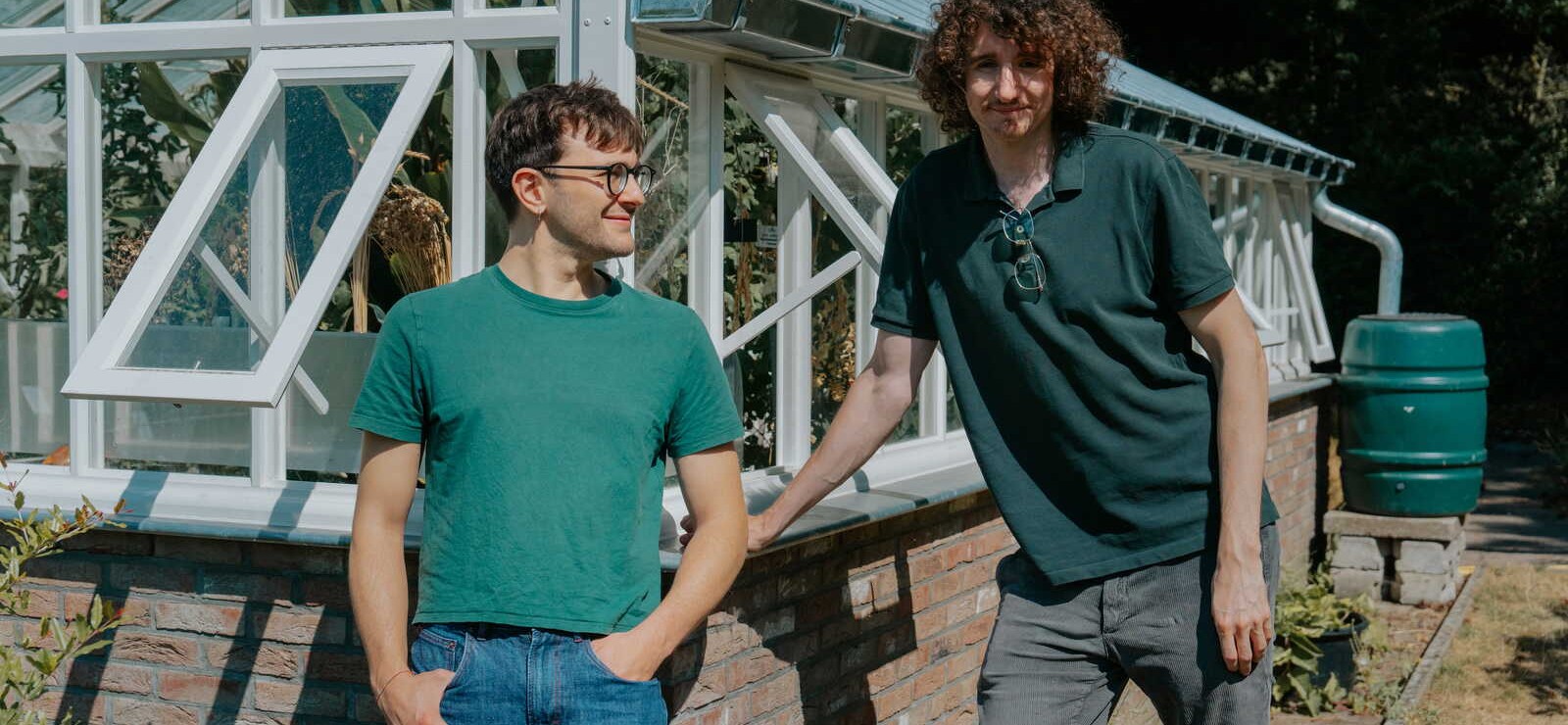 Victor en Leonardo leunen tegen een serre in de tuin.