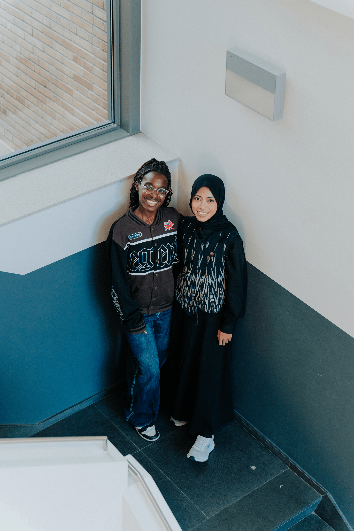 Aini en Ariana staan naast elkaar in de hoek van een trap van de Therminal in Gent.