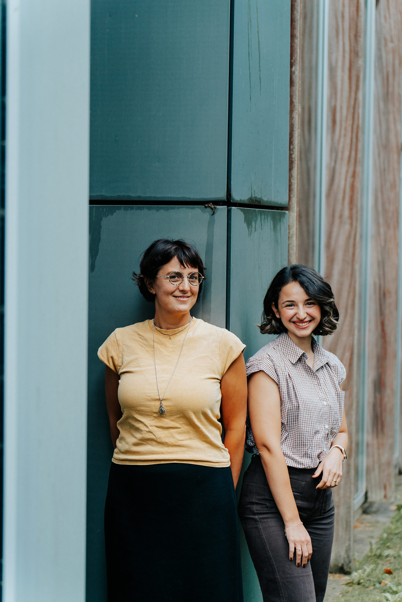Francesca en Melis leunen tegen een steunpilaar van een gebouw
