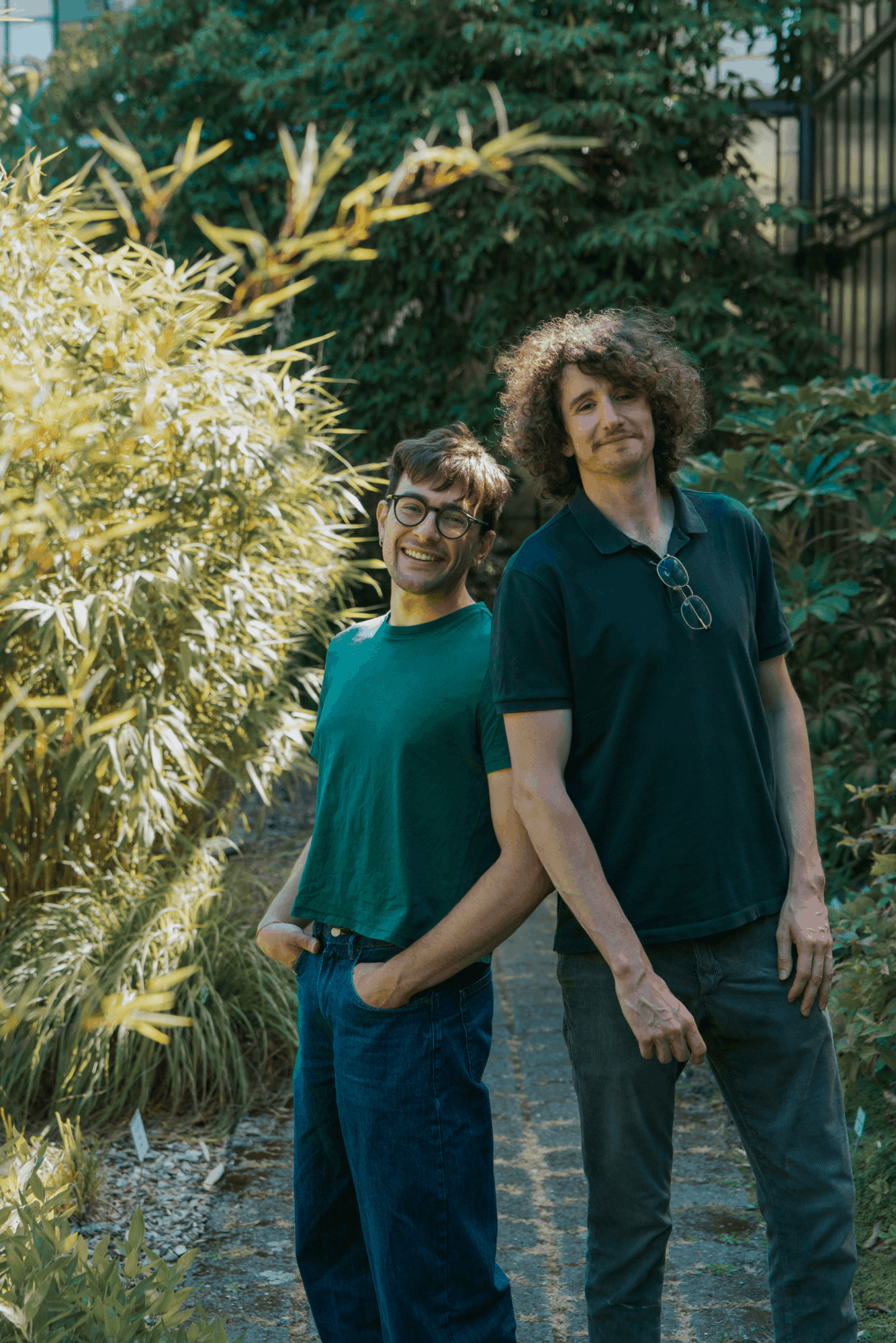 Victor en Leonardo leunen met hun rug tegen elkaar in de tuin