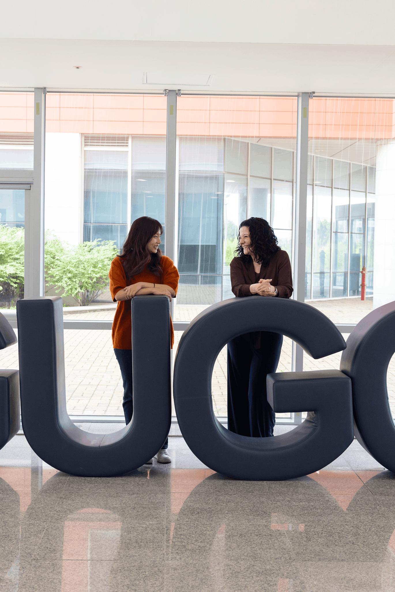 Mara and Terry kijken naar elkaar terwijl ze leunen op het logo van GUGC