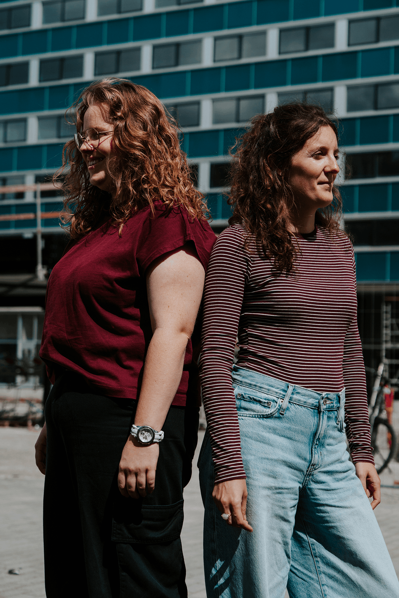 Twee jonge vrouwen, Charlotte en Rune staan rug aan rug voor een home van UGent.