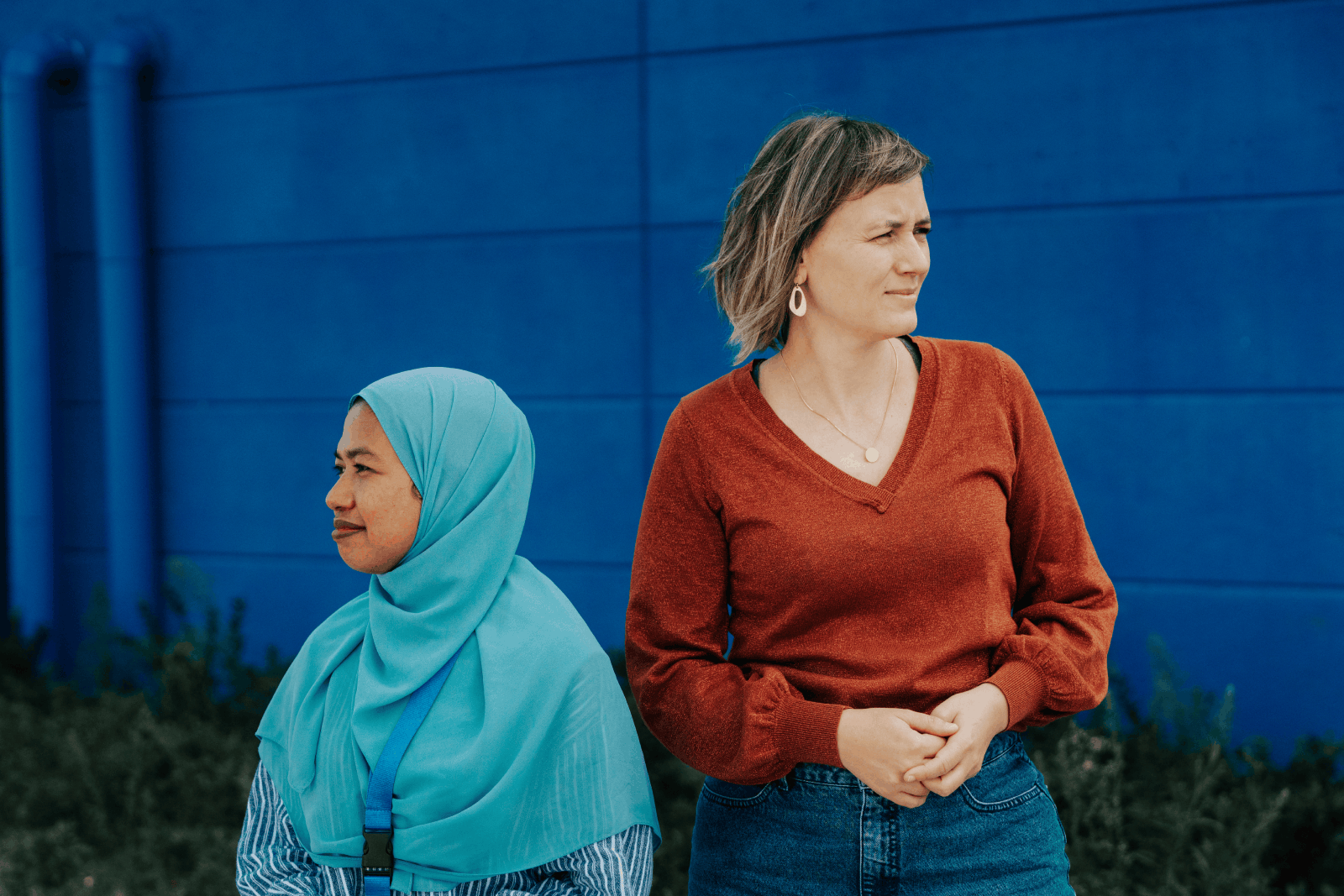 Ellen en Tina staan voor een gebouw met diepblauwe muren.