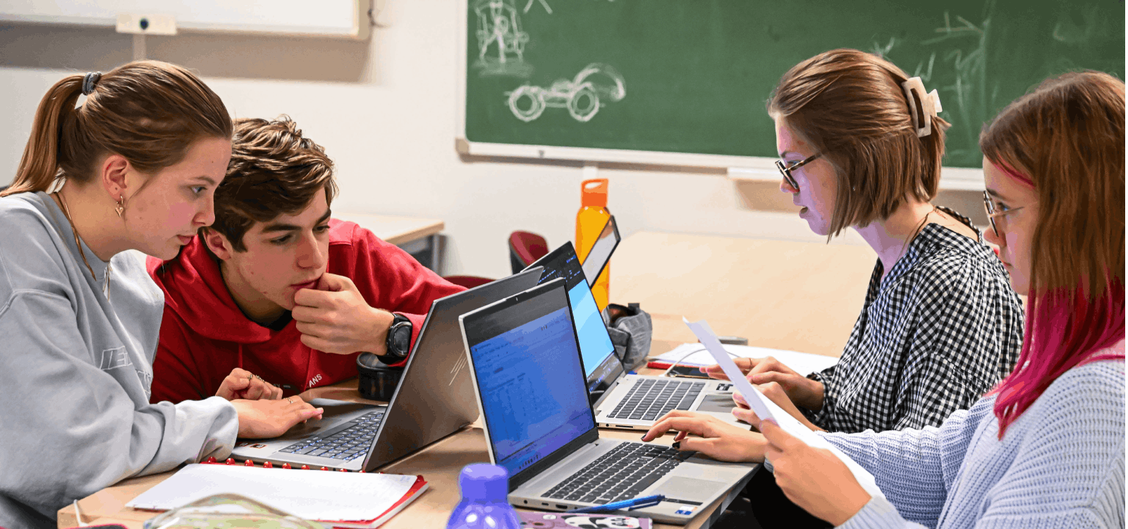 Studenten burgerlijk ingenieur lossen technische problemen op aan een tafel met hun laptops.