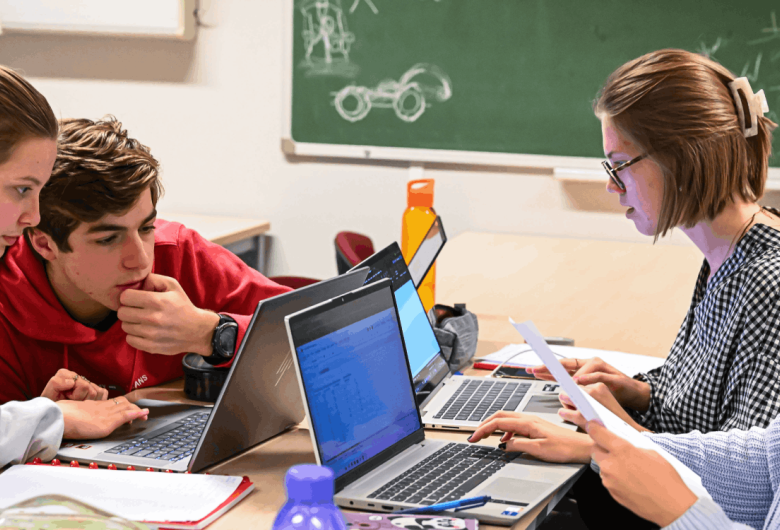 Studenten burgerlijk ingenieur lossen technische problemen op aan een tafel met hun laptops.