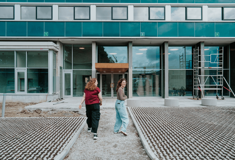 Twee jonge vrouwen, Charlotte en Rune lopen naar de ingang van een home van UGent.