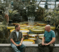 Lars en Herbert voeren een gesprek met elkaar naast reusachtige lelies